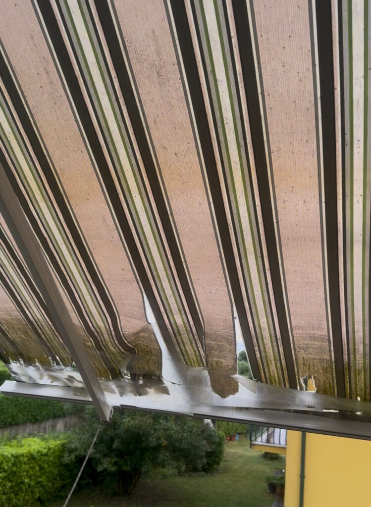 Dettaglio delle cuciture cedute su un telo di tenda da sole