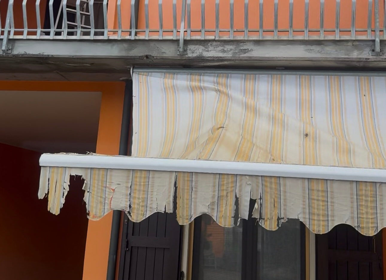 Tenda da sole con il telo sfilacciato ai bordi, da sostituire